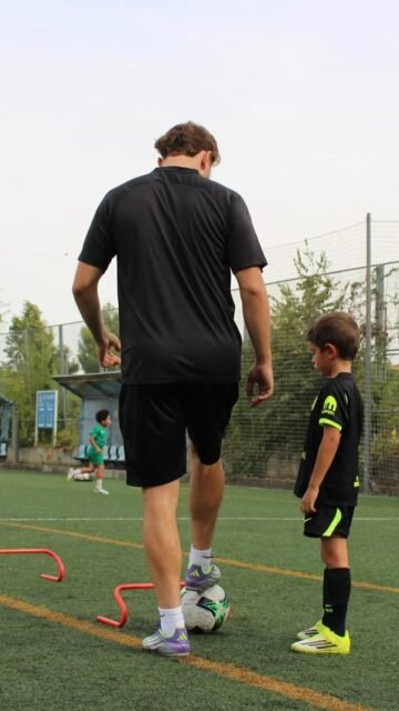 Entrenador con un niño durante un ejercicio de seguimiento personalizado de tecnificación de fútbol en Madrid